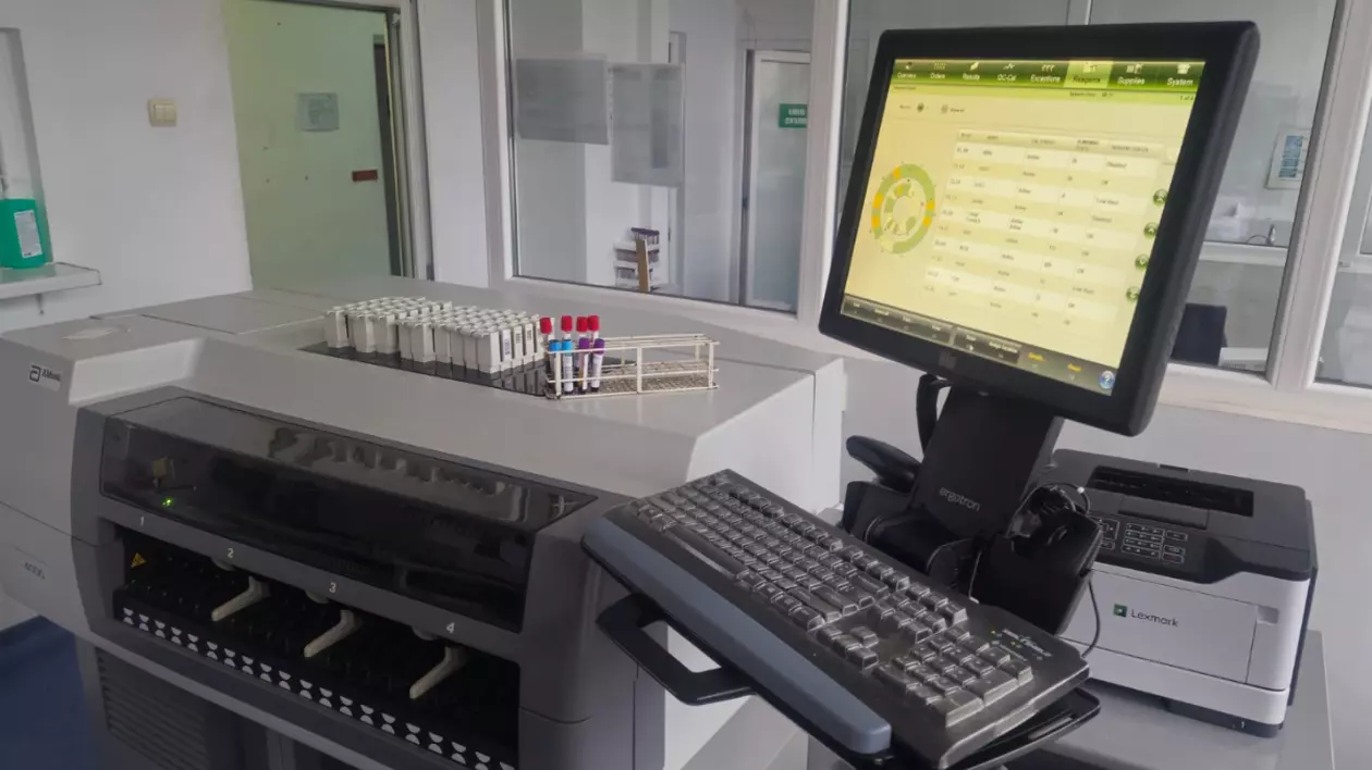 Imaginea arată un aparat pe care sunt așezate mai multe tuburi de recoltare, iar pe monitor se văd datele probelor analizate.