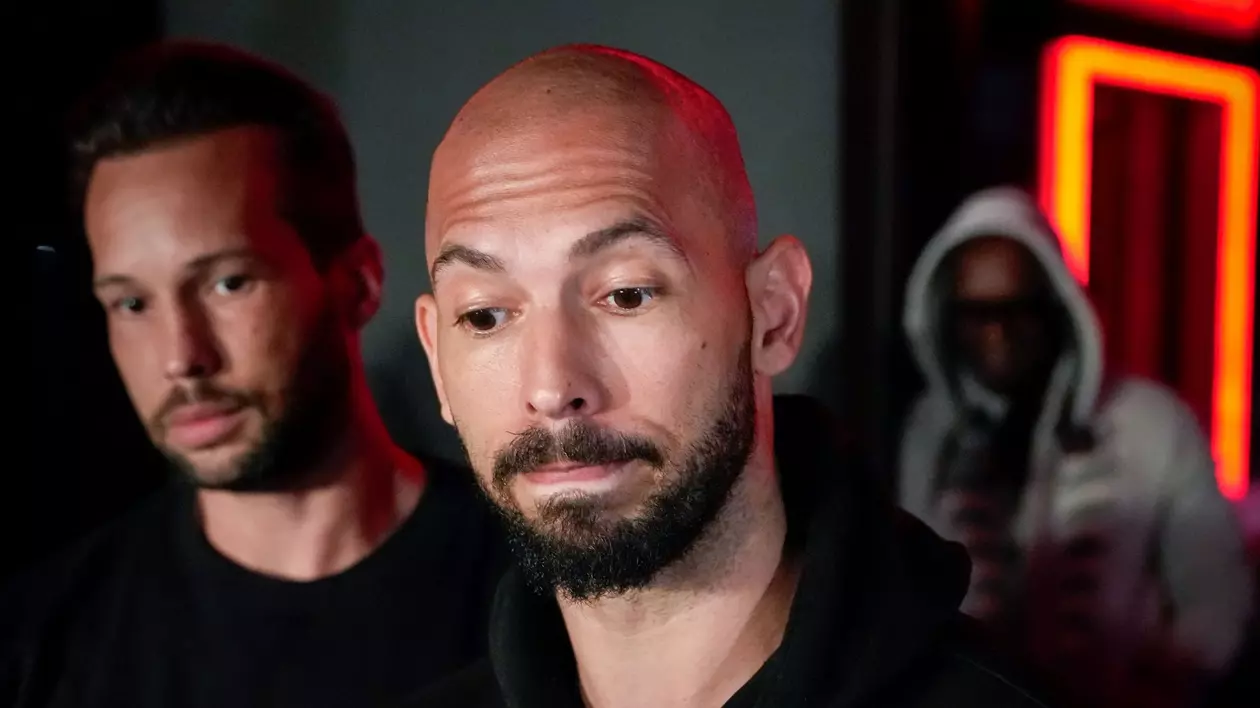 Andrew Tate surprins în timp ce ridică din sprâncene, iar în spatele său se află Tristan Tate