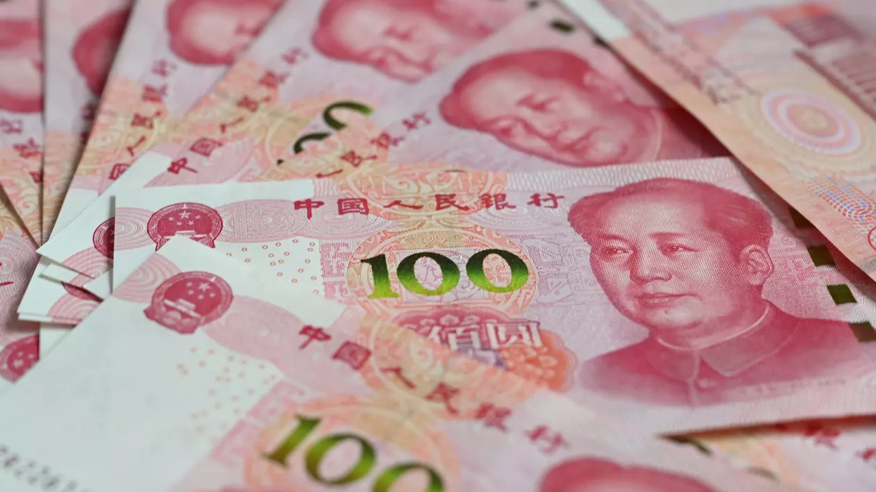 Bancnote de 100 de yuani chinezești zac pe o masă. FOTO: Hepta.