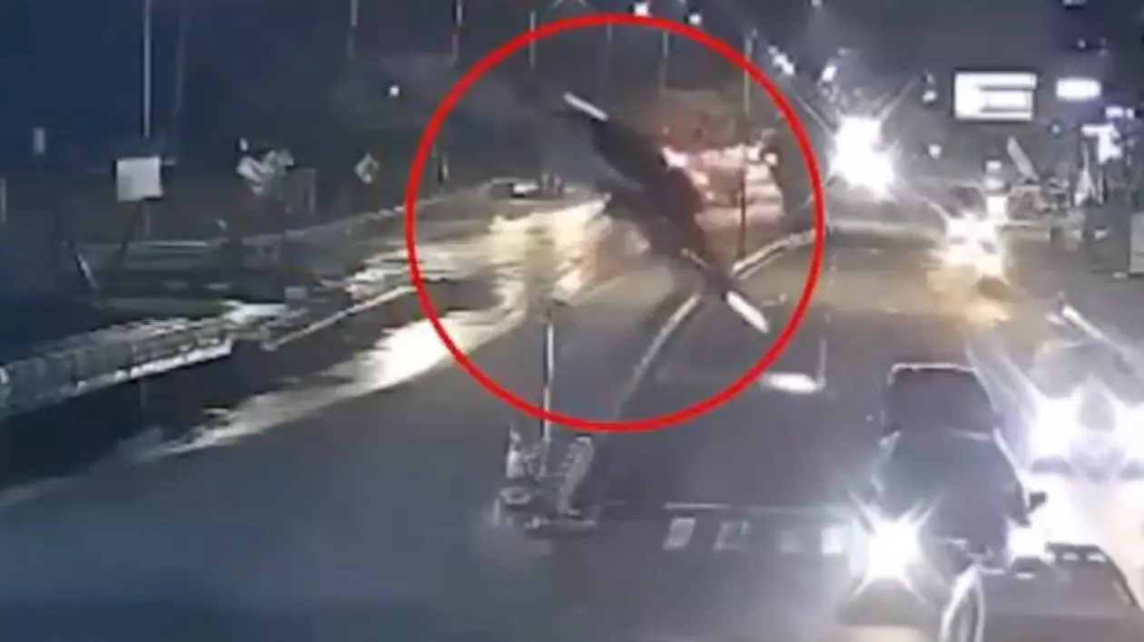 BMW-ul surprins în aer, înainte de a se prăbuși pe o șosea din Indonezia. Mai multe mașini se află pe șosea