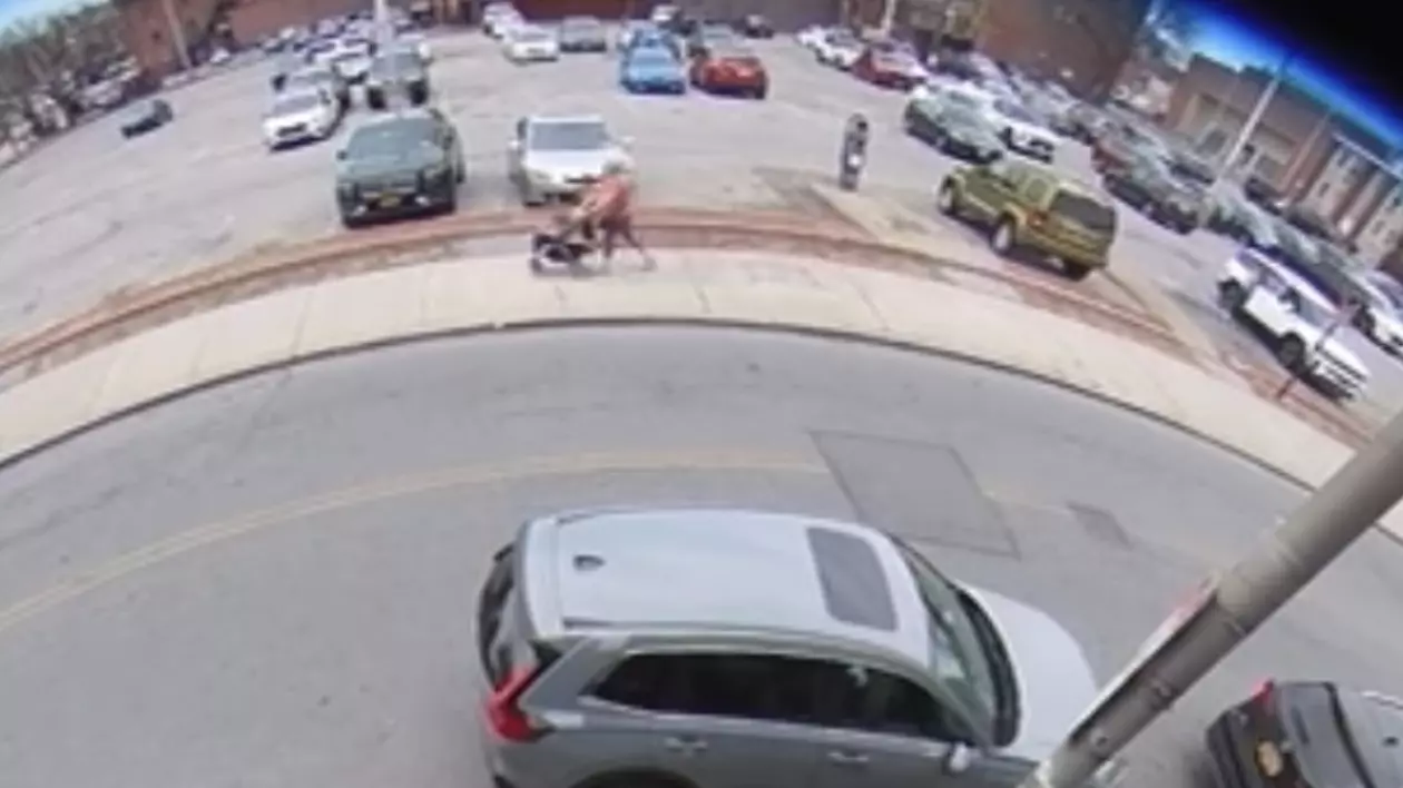 Imaginea este surprinsă de camera de supraveghere. Aceasta ilustrează o femeie pe stradă și mașini