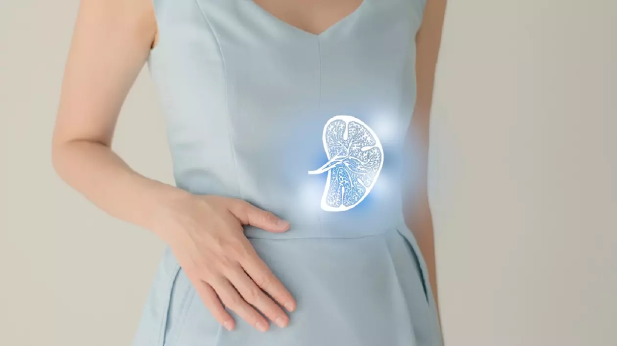 O femeie îmbracată într-o rochie bleu își ține mâna dreaptă pe abdomen, iar în stanga, pe rochie, are desenata splina