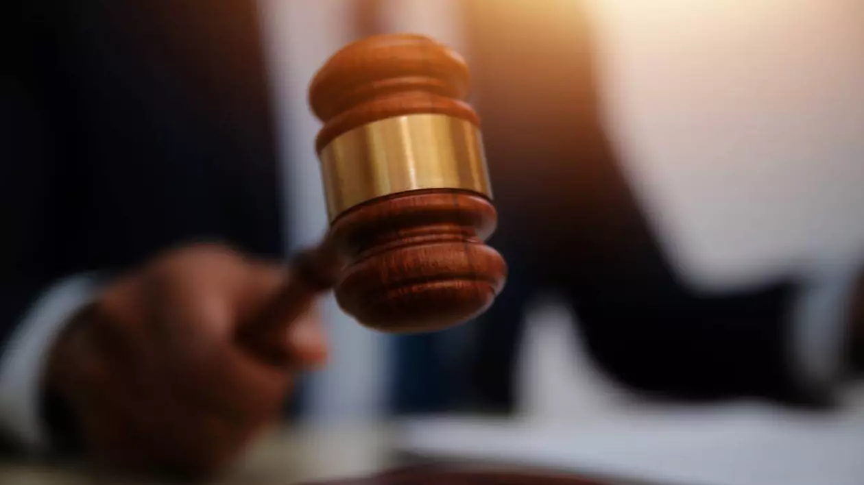 Ciocan judecătoresc, ținut în mână de un judecător îmbrăcat cu o robă specifică.