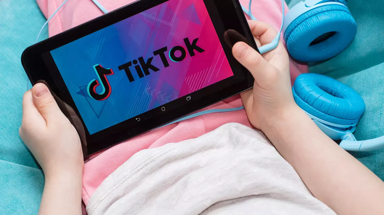 Copil cu tableta in mana cu pictograma TIK TOK shutterstock_1651757992