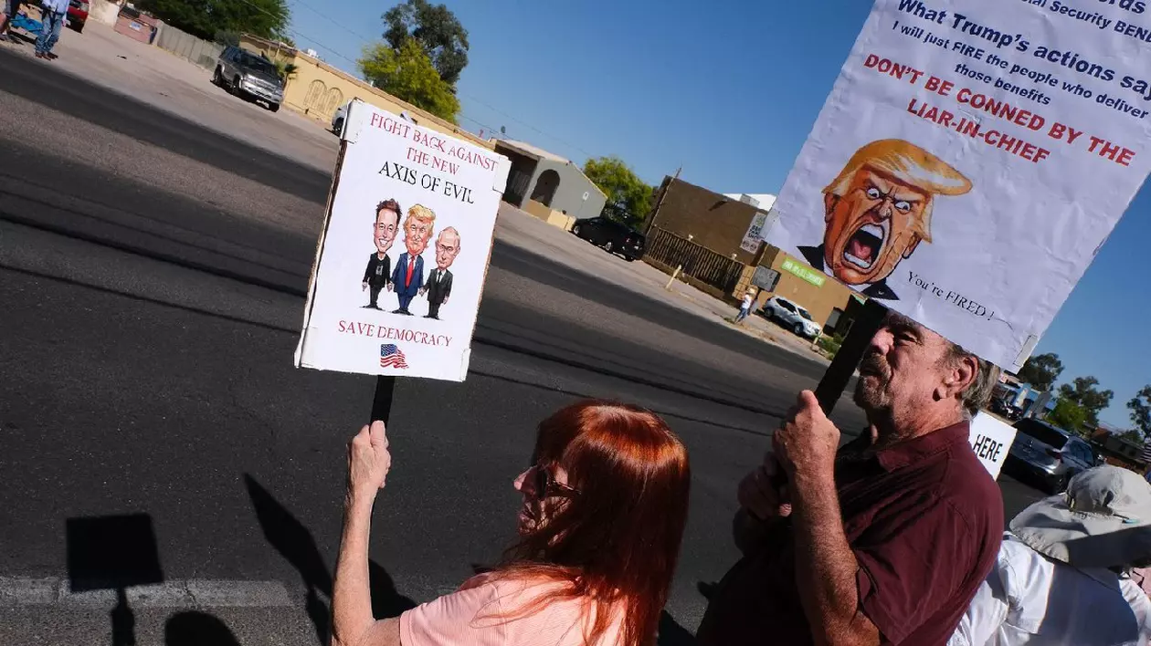 26 aprilie 2025, Tucson, Arizona, SUA: Protestatarii din fața biroului Administrației Securității Sociale din Tucson demonstrează împotriva posibilelor reduceri ale programului de securitate socială pentru a economisi bani pentru reducerile de taxe propuse de Trump. Aceștia se opun accesului lui Elon Musk la dosarele de securitate socială ale americanilor și concedierii de către DOGE a angajaților din domeniul securității sociale, reducerilor bugetare și închiderii birourilor din întreaga țară
