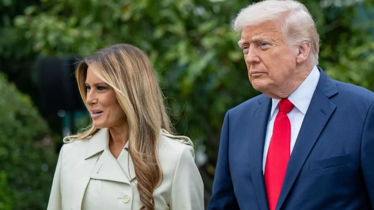 In imagine președintele Donald Trump, in costum inchis la culoare si cravata rosie, alături de el soția sa, Melania, intr-un pardesiu crem
