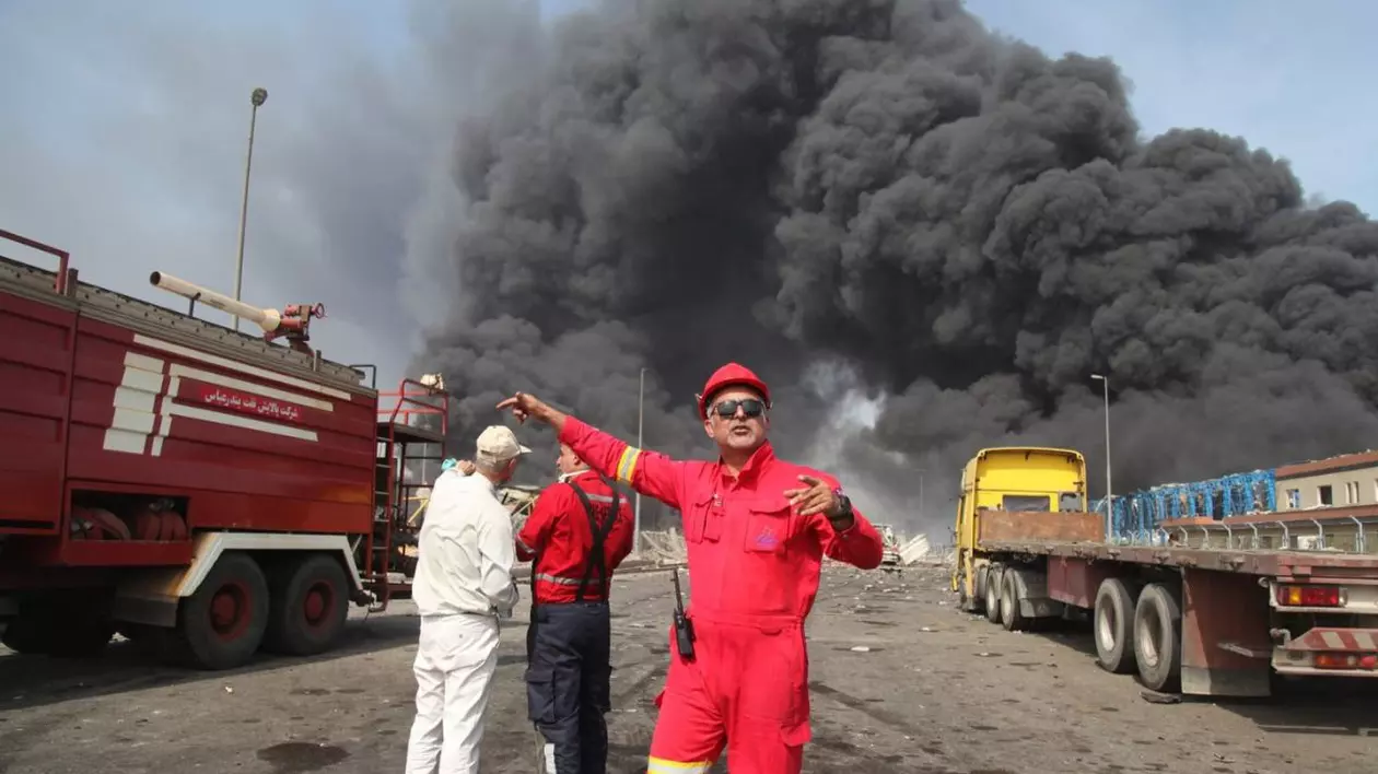 Fum negru și dens se ridică în timp ce echipele de salvare ajung în apropierea sursei unei explozii în portul Shahid Rajaee, la sud-vest de Bandar Abbas, în provincia iraniană Hormozgan, pe 26 aprilie 2025.