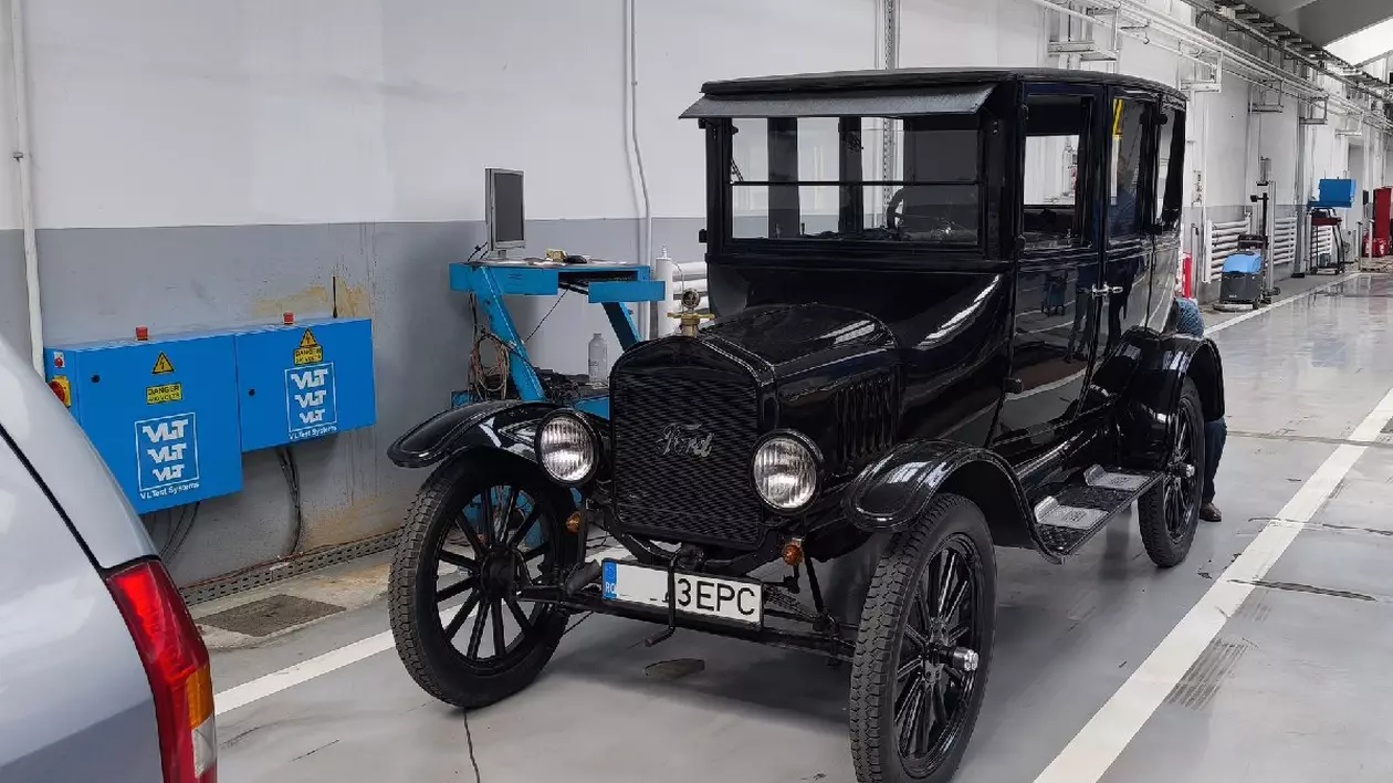 O mașină clasică, de epocă, de culoare neagră - Ford T, într-o hală a Registrului Auto Român.