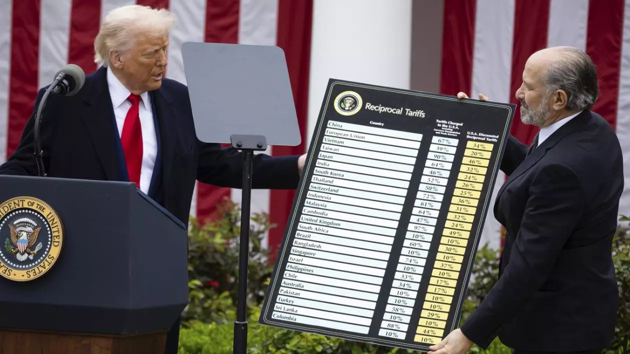 Președintelui Donald Trump primește o diagramă de către secretarul pentru Comerț, Howard Lutnick, care afișează tarifele reciproce între SUA și țările străine în timpul unui eveniment „Make America Wealthy Again” în Grădina de Trandafiri de la Casa Albă, 2 aprilie 2025.