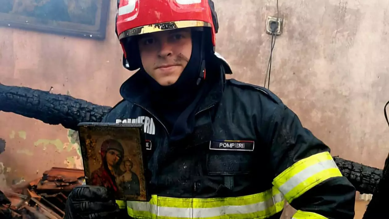 Icoana rămasă neatinsă după un incendiu violent din Brașov, ținută în mână de um pomier, aflat în mijlocul unei camere acoperite de funingine