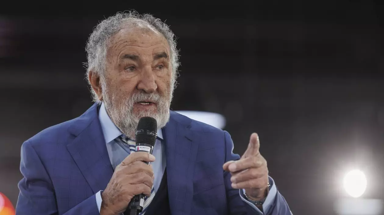 ion tiriac imbracat intr-un sacou albastru in timpul unei conferinte vorbind la un microfon