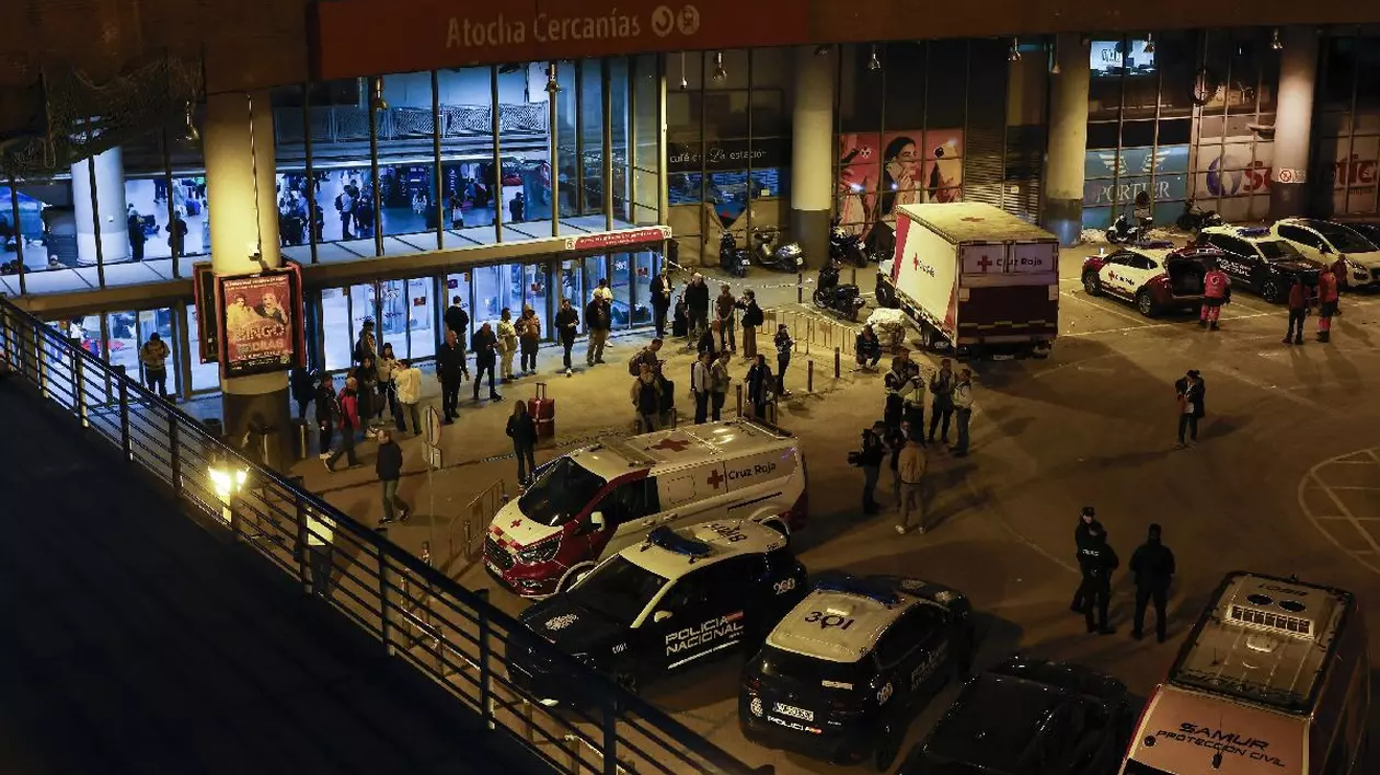 Ambulanțe și mașini de poliție sunt parcate în fața gării Atocha, în timp ce mulți călători se pregătesc să petreacă noaptea înăuntru, în urma unei pene masive de curent care a afectat întreaga peninsulă Iberică și sudul Franței, la Madrid, pe 28 aprilie 2025
