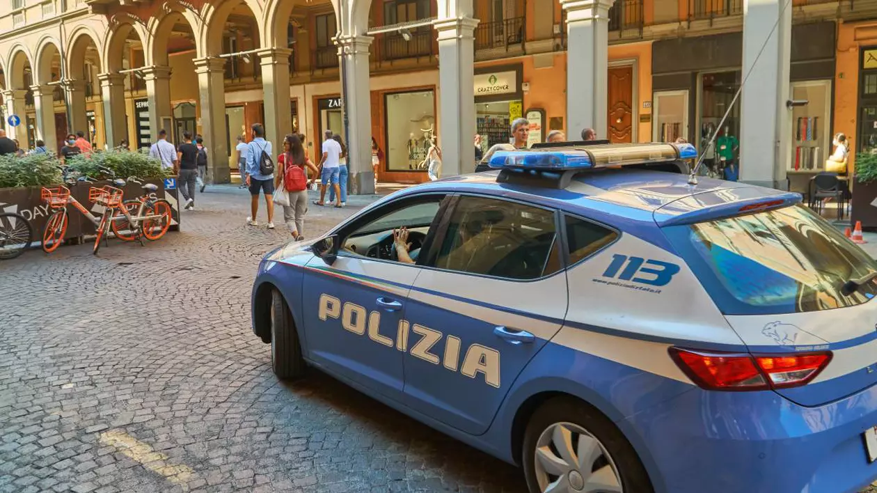 masina de politie italia, pe un drum pietonal acoperit cu piatra cubica, se observa spatiul amenajat al unui restaurant