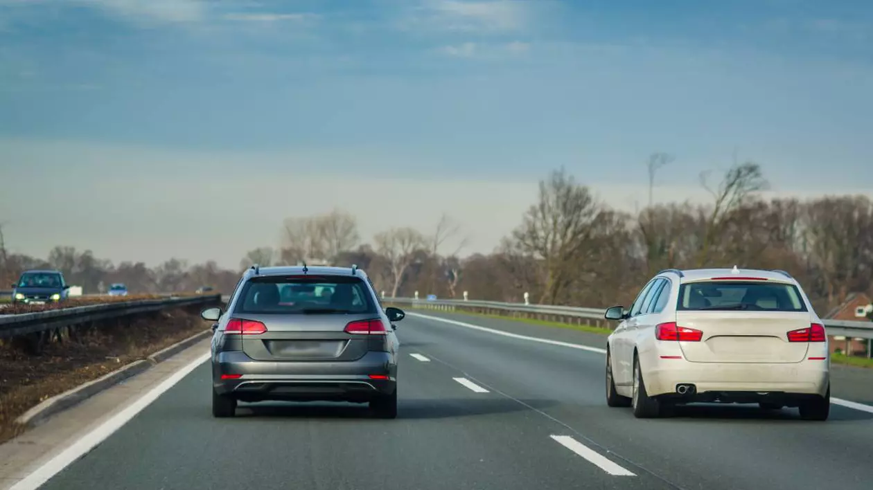 Două mașini aflate pe o autostradă cu două benzi pe sens.