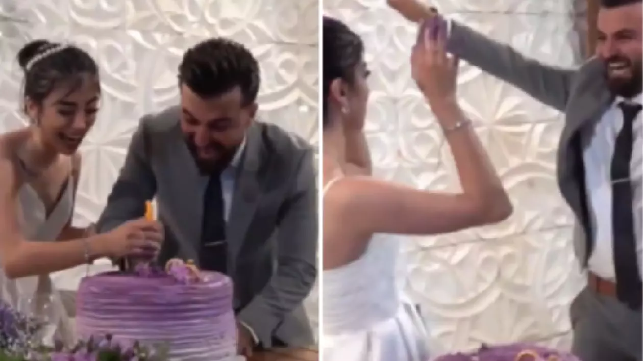 Mireasa poartă o rochie albă, fără bretele,mirele este îmbrăcat într-un costum gri, cămașă albă și cravată închisă la culoare.Cei doi se află în fața unui tort de nuntă mare, rotund, decorat în nuanțe de mov și lila, cu detalii florale