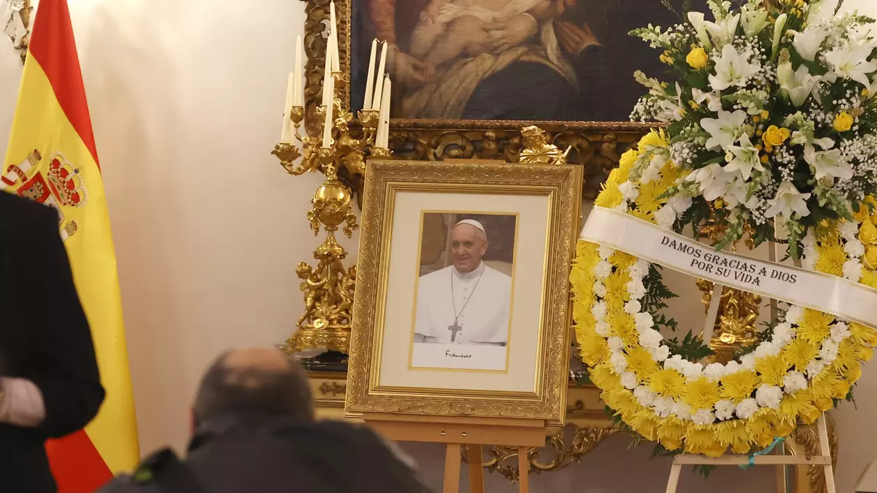 Un tablou al Papei Francisc, alături de o coroană din flori albe și galbene, la Palatul Apostolic