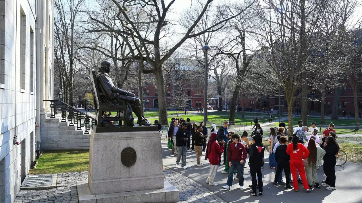 Oamenii adunați în jurul statuii lui John Harvard în Harvard Yard pe 15 aprilie 2025, la Universitatea Harvard din Cambridge, MA.