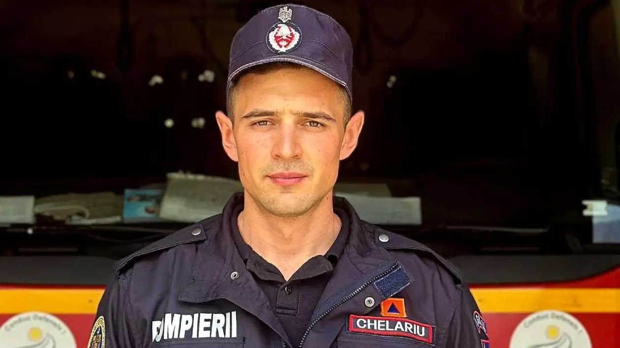Poză cu pompierul din cadrul ISU Brașov care a intervenit la accident. Este îmbrăcat în uniformă, iar în spate se află o autospecială