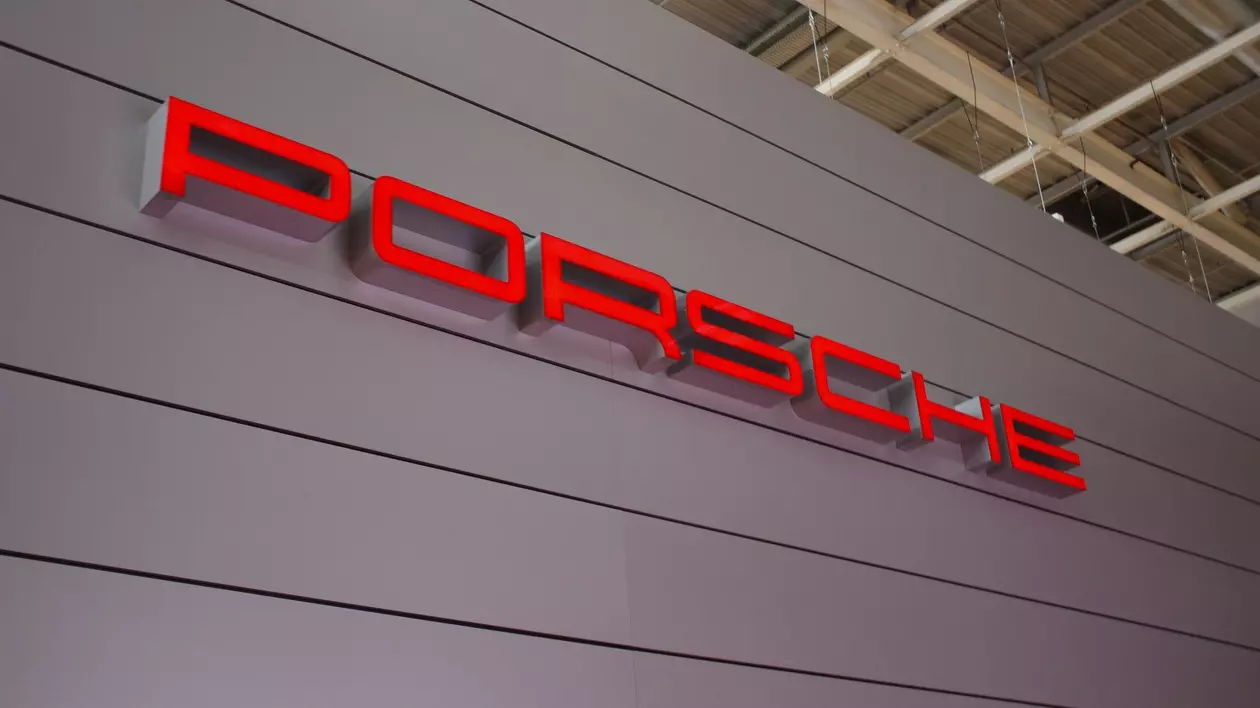 Porsche scris cu majuscule pe un perete gri