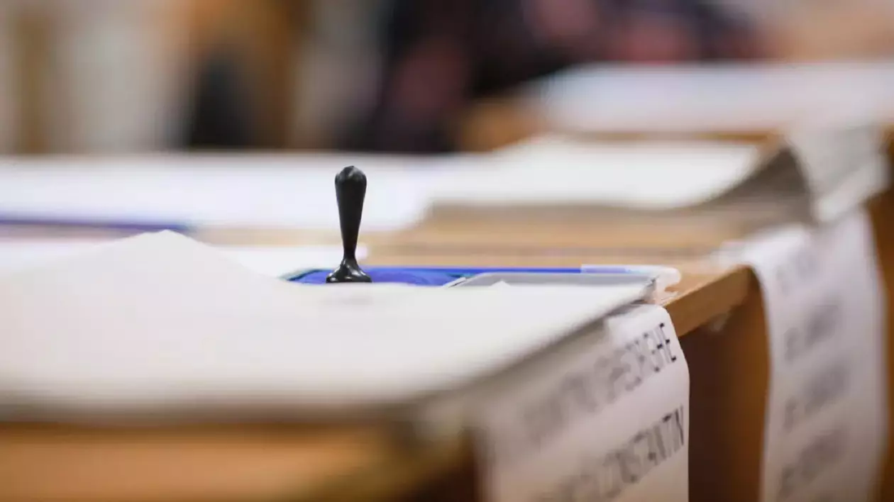 O stampila se afla pe un birou intr-o sectie de votare, iar langa ea se vad mai multe hartii