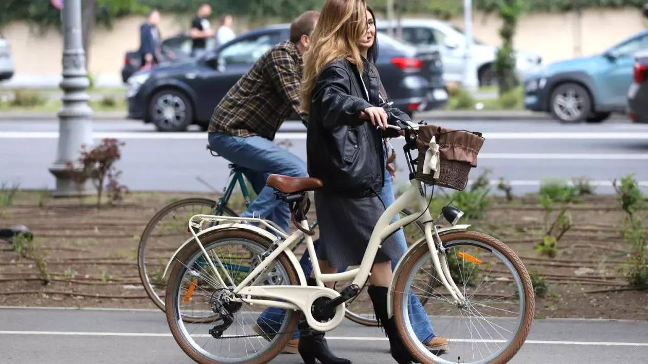 O tânără merge pe lângă bicicleta pe care o ține de coarne și vorbește cu o prietenă, iar paralel cu ele, pe aceeași stradă, un tânăr merge pe biciletă. În spate, se văd mașini care circulă pe stradă și alți oameni, într-o zi însorită de primăvară