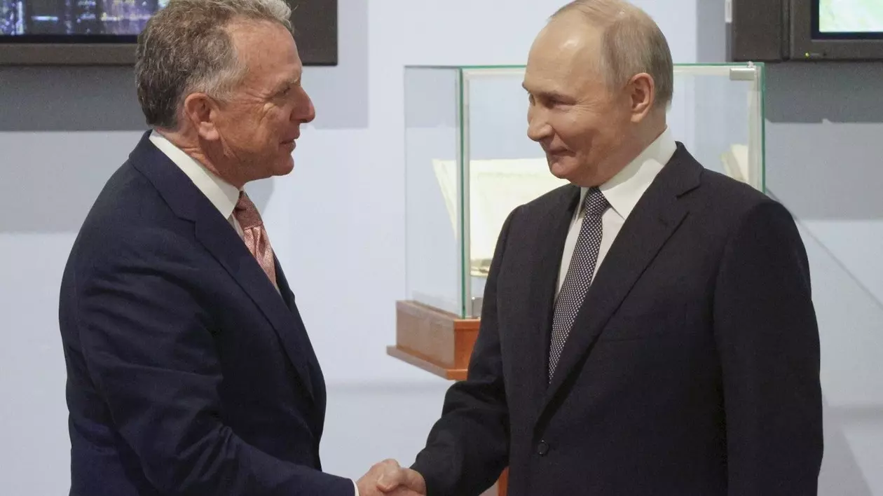 Vladimir Putin zâmbește, în dreapta, în timp ce dă mâna cu trimisul lui Donald Trump, Steve Witkoff