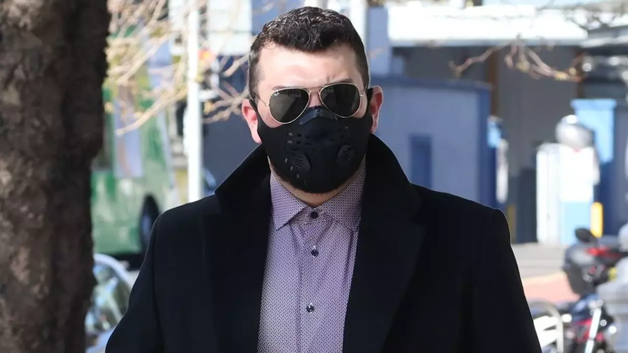 Românul condamnat în Dublin, după ce a vândut țuică și vinuri românești, cu ochelari de soare la ochi și mască neagră de protecție, se află pe stradă