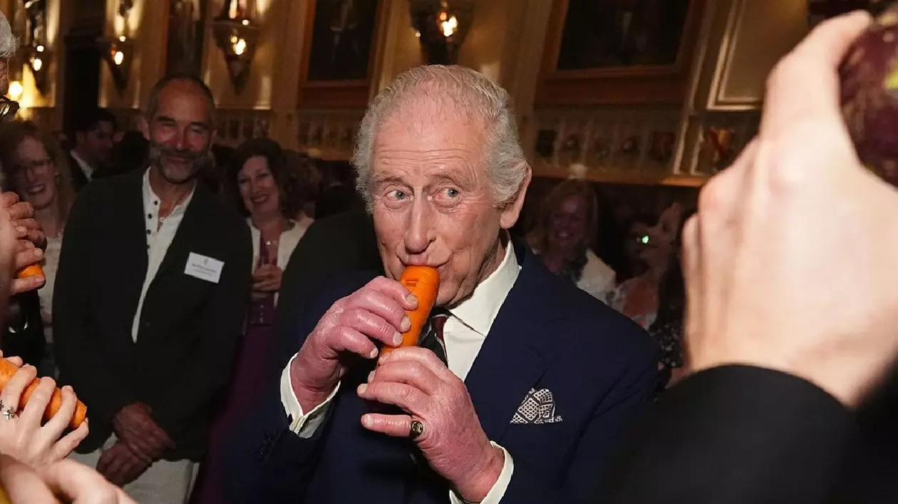 03/04/2025. Windsor, Regatul Unit. Regele Carol al III-lea cântă la un morcov cu London Vegetable Orchestra în timpul unei recepții pentru a-i recunoaște pe cei implicați în muzica comunitară la Castelul Windsor, Regatul Unit.