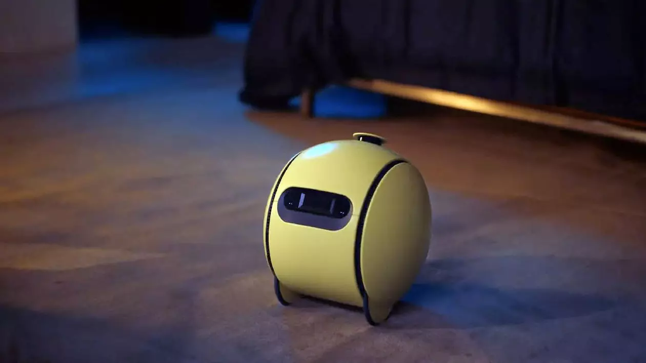Un robot Samsung Ballie galben, așezat pe parchetul unei locuințe.
