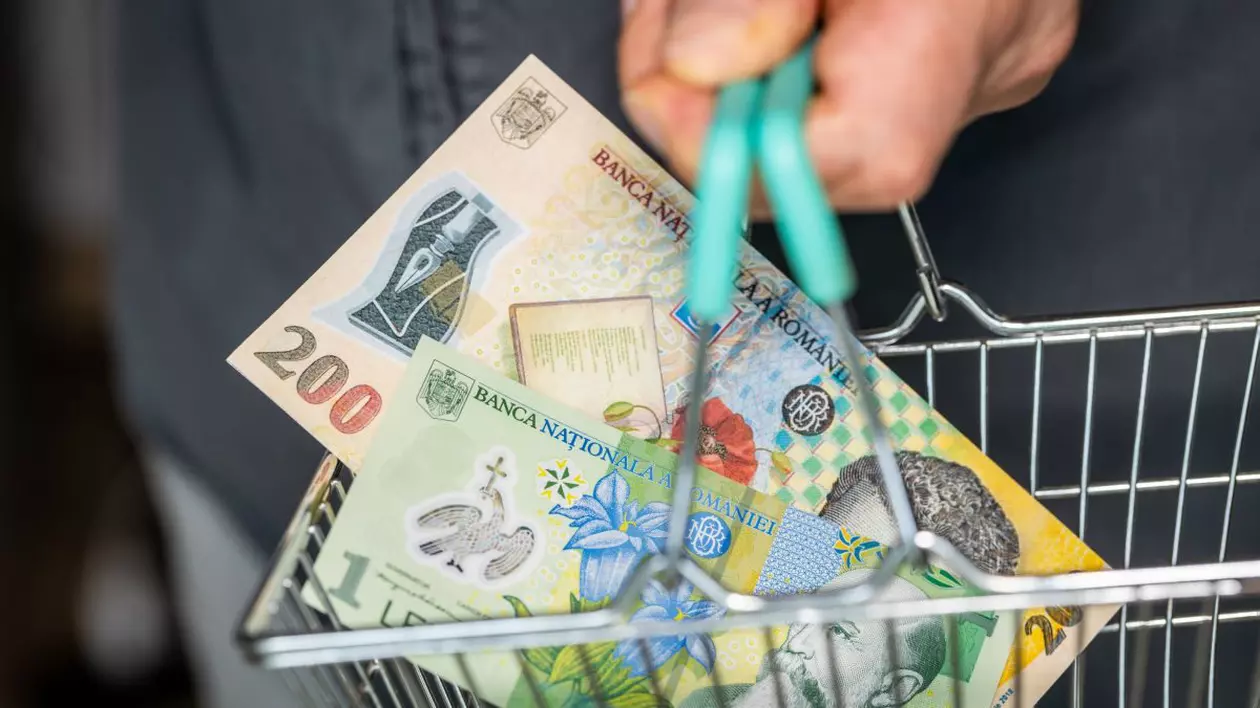 Un bărbat ține în mână un coș de cumpărături de mărime foarte mică, în care se vede o bancnotă de 200 de lei și una de un leu