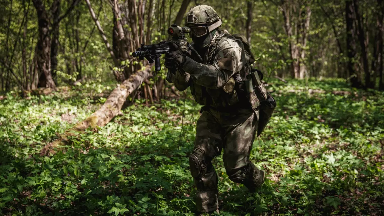 Soldat rus surprins într-o pădure, având o armă în mâini