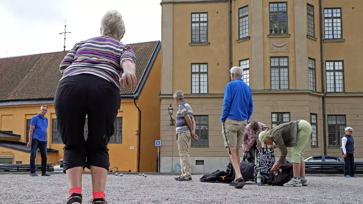 Oameni de difeite vârste în curtea interioara a unei clădiri din Suedia, Stockholm.