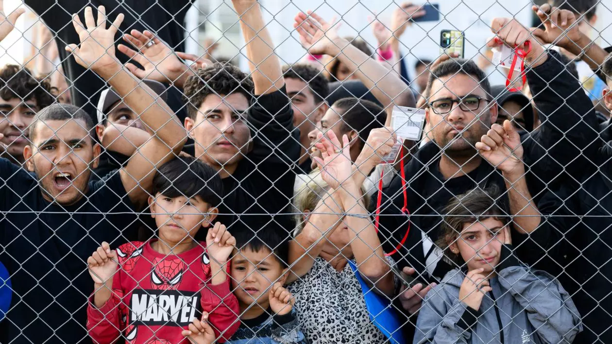 Tabără de imigranți din Grecia, copii și tineri în spatele unui gard.