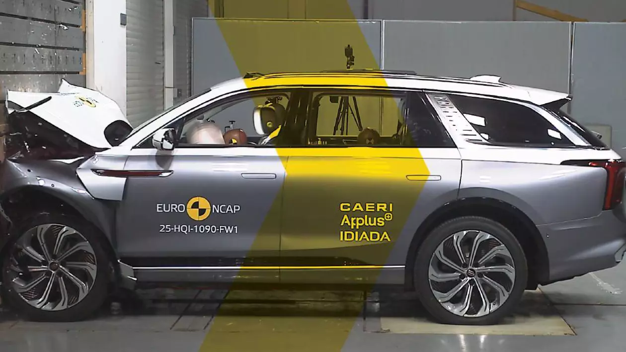 masina electrica de culoare gri in urma unui test auto, cu partea din fata lovita de un perete