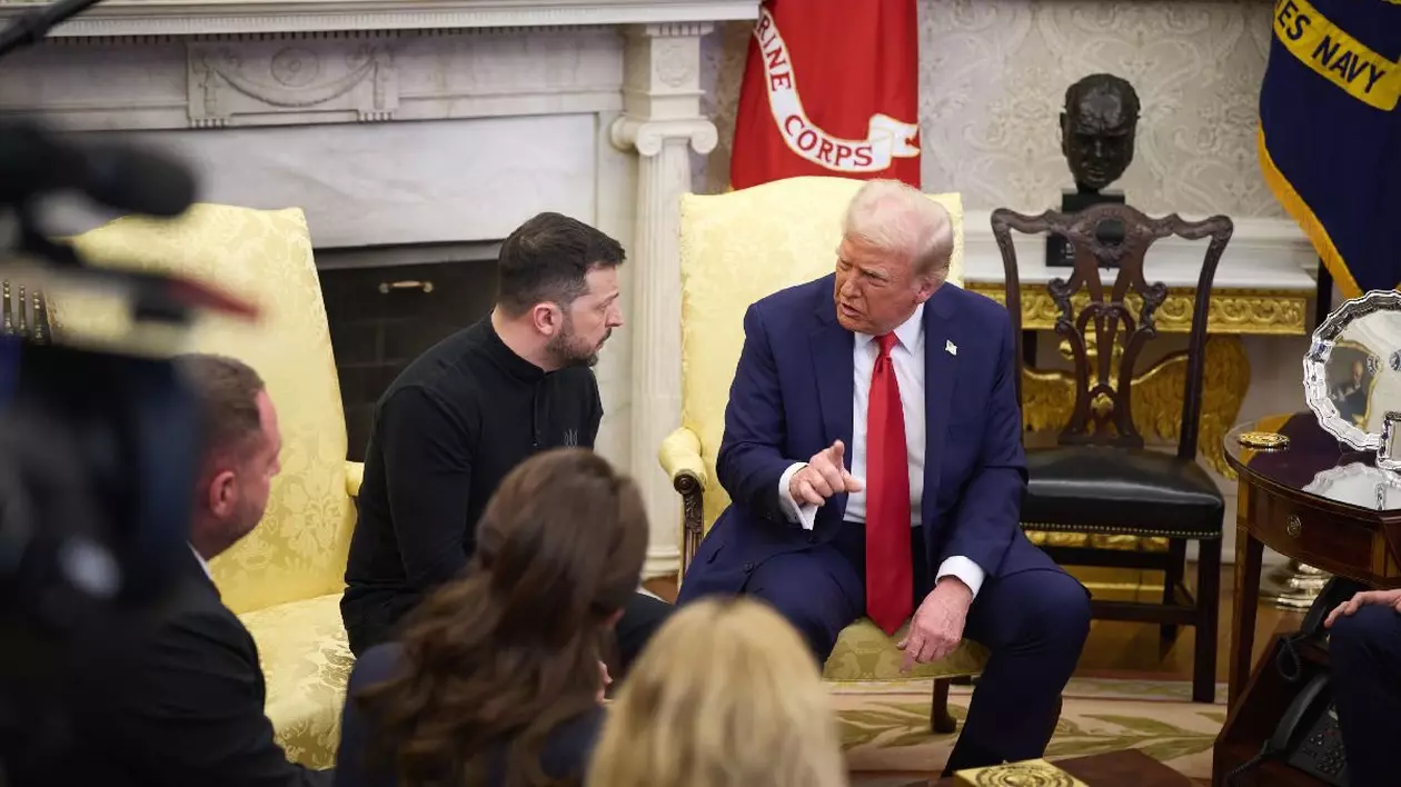 Doi bărbați stau pe două fotolii și discută. Cel din dreapta, Donald Trump, e în costum și are cravată roșie. Cel din stânga, Volodimir Zelenski, poartă un pulover închis la culoare