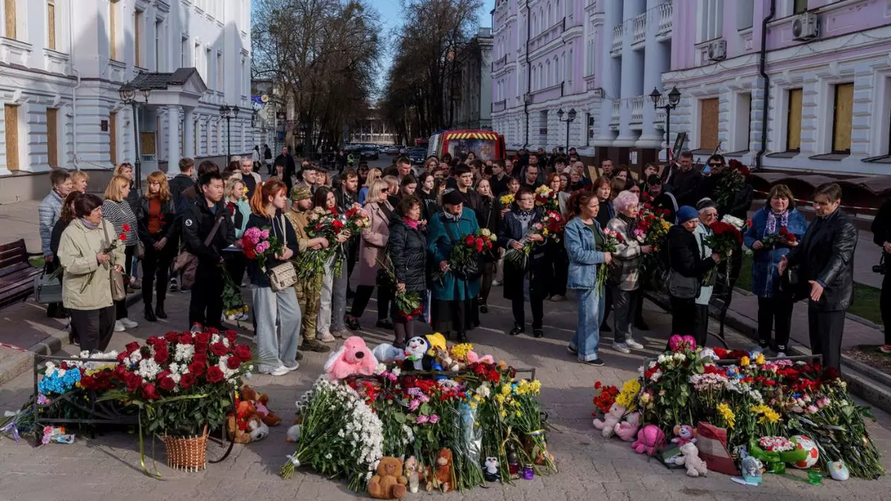 Oamenii vin să pună flori pe locul morții Olenei Kohut, o muziciană de orchestră care a fost ucisă într-un atac rusesc mortal din Duminica Floriilor asupra orașului Sumy pe 13 aprilie, în timpul unei ceremonii de rămas bun în Sumy, Ucraina, 15 aprilie 2025.