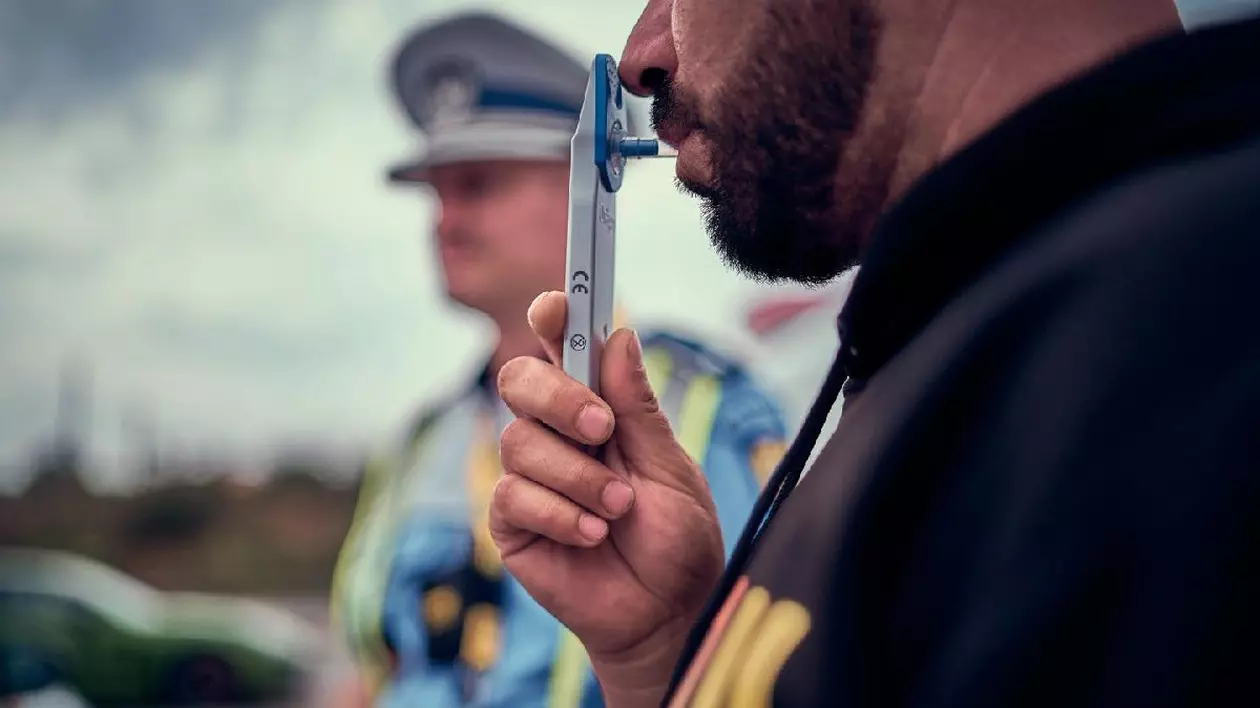 un politist și un șofer care suflă într-un drugtest