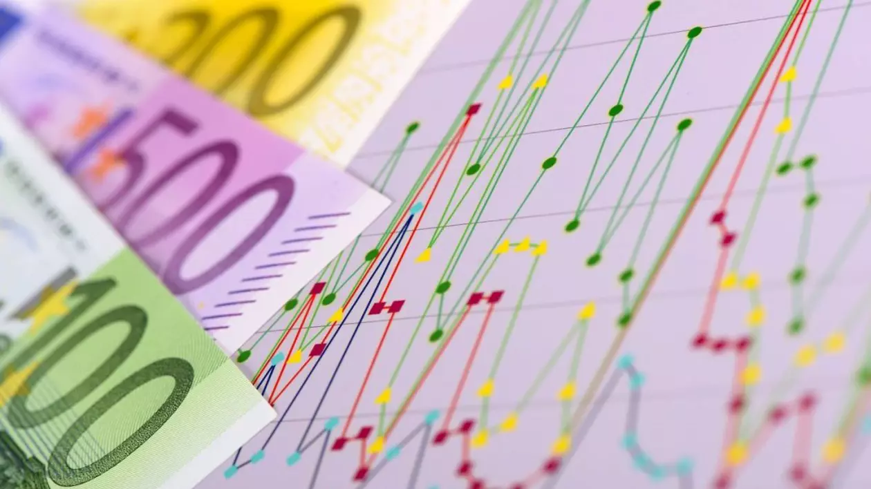 Graficul unei burse, cu linii verzi, galbene și roșii, alături de bancnote în euro