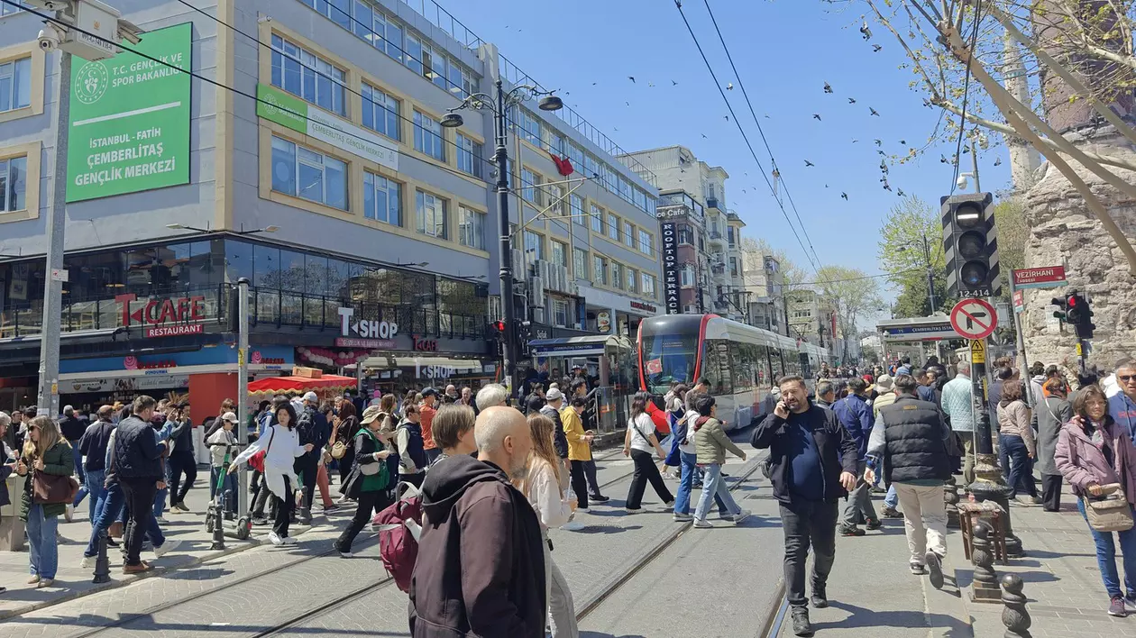 Mulți oameni pe o stradă din Istanbul. În spate se vede un tramvai.