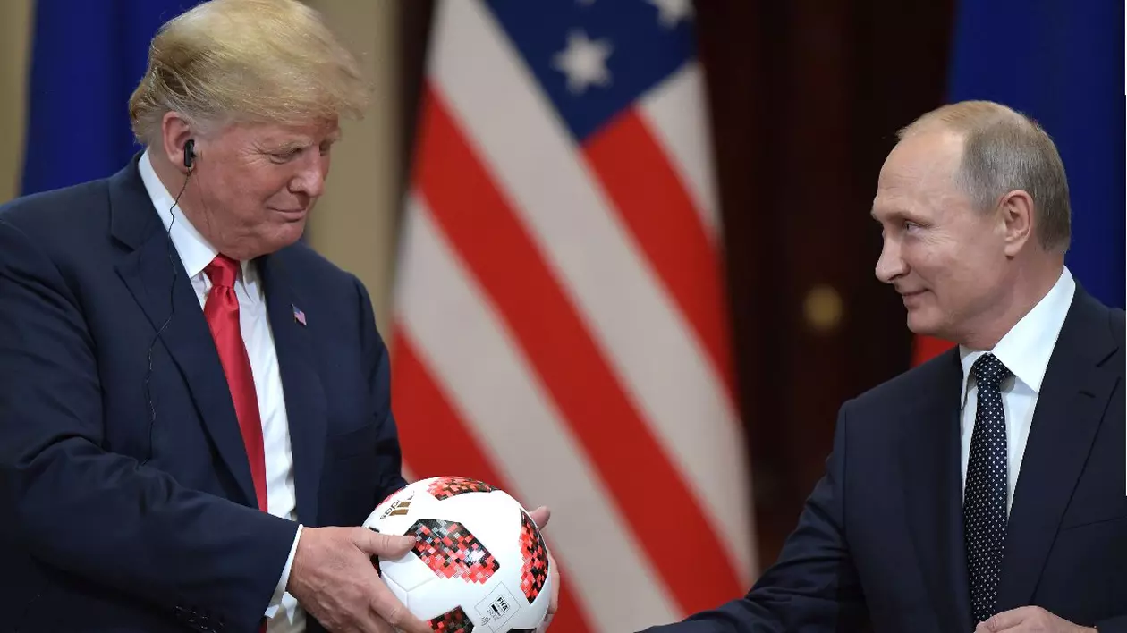 Președintele rus Vladimir Putin îi oferă o minge de fotbal lui Donald Trump, în spate se vede steagul SUA - conferința de presă comune care a urmat întâlnirii de la Helsinki, din 2018