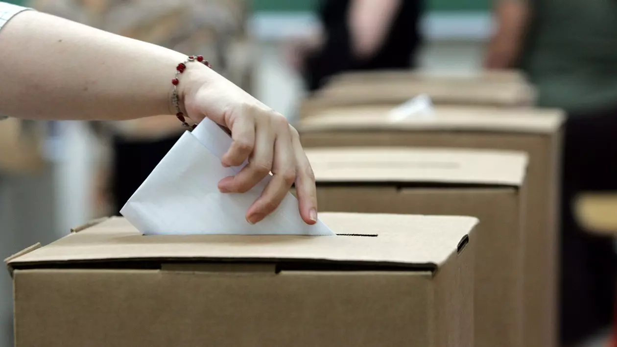 Femeie care introduce într-o urnă buletinul de vot