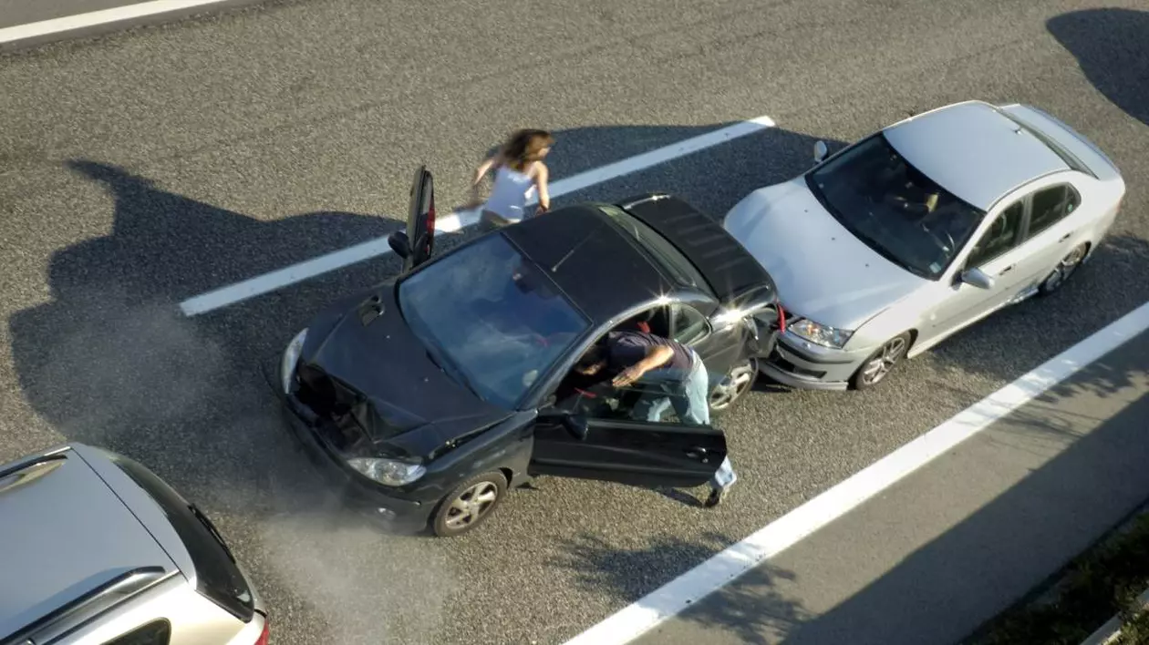 Accident în lanț pe o autostradă cu două benzi pe un sens. O mașină de culoare gri a lovit din spate o mașină neagră, care la rândul ei a intrat într-un al treilea vehicul bej aflat în față.
