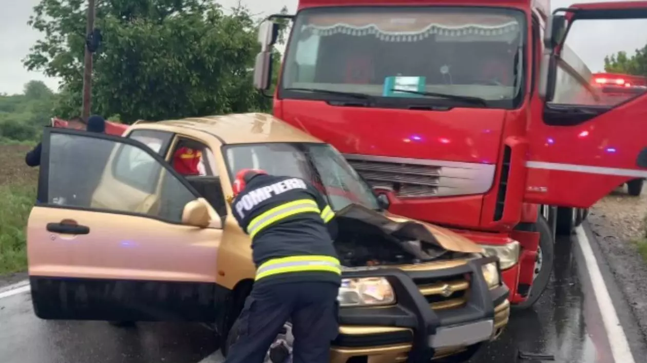 Un echipaj de pompieri care intervine la mașina accidentată strivită de camionului de la Sarcău.