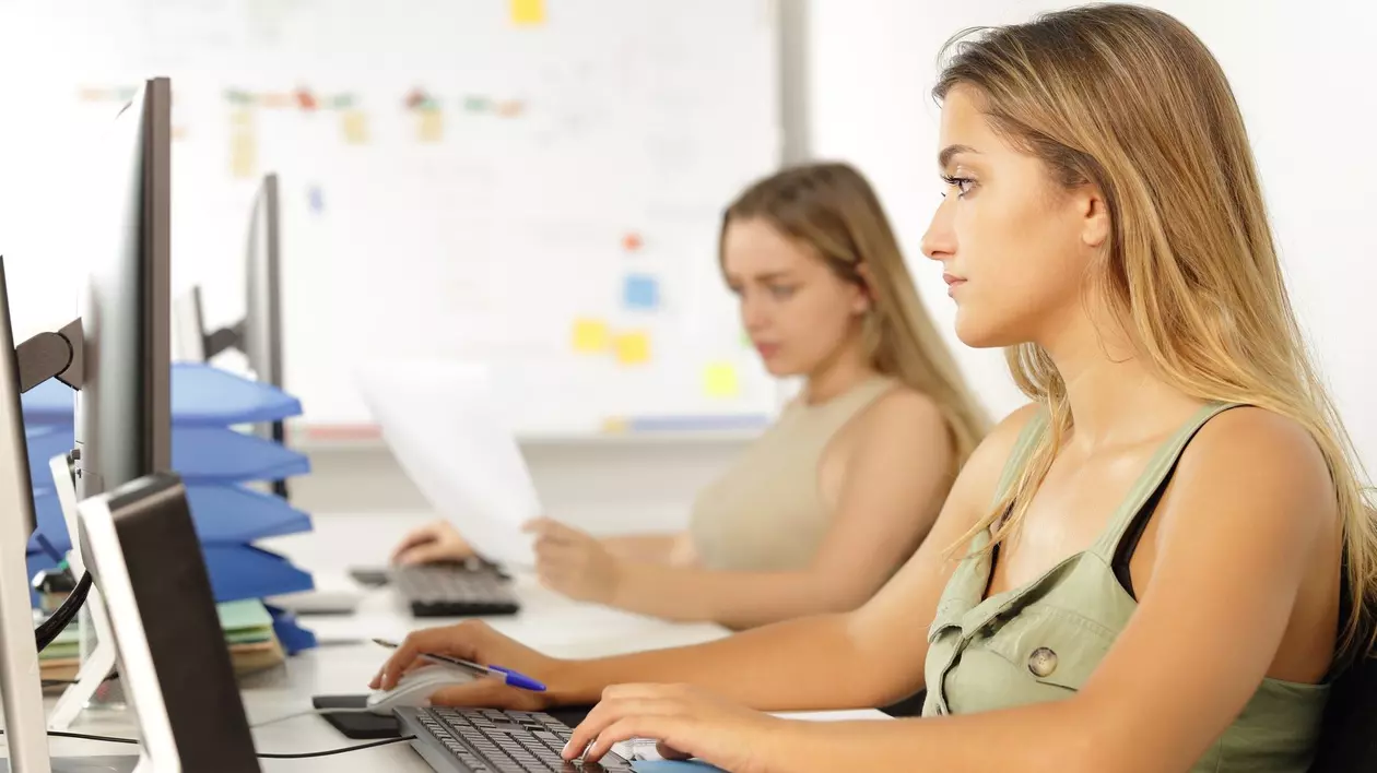 Două angajate care lucrează la calculator