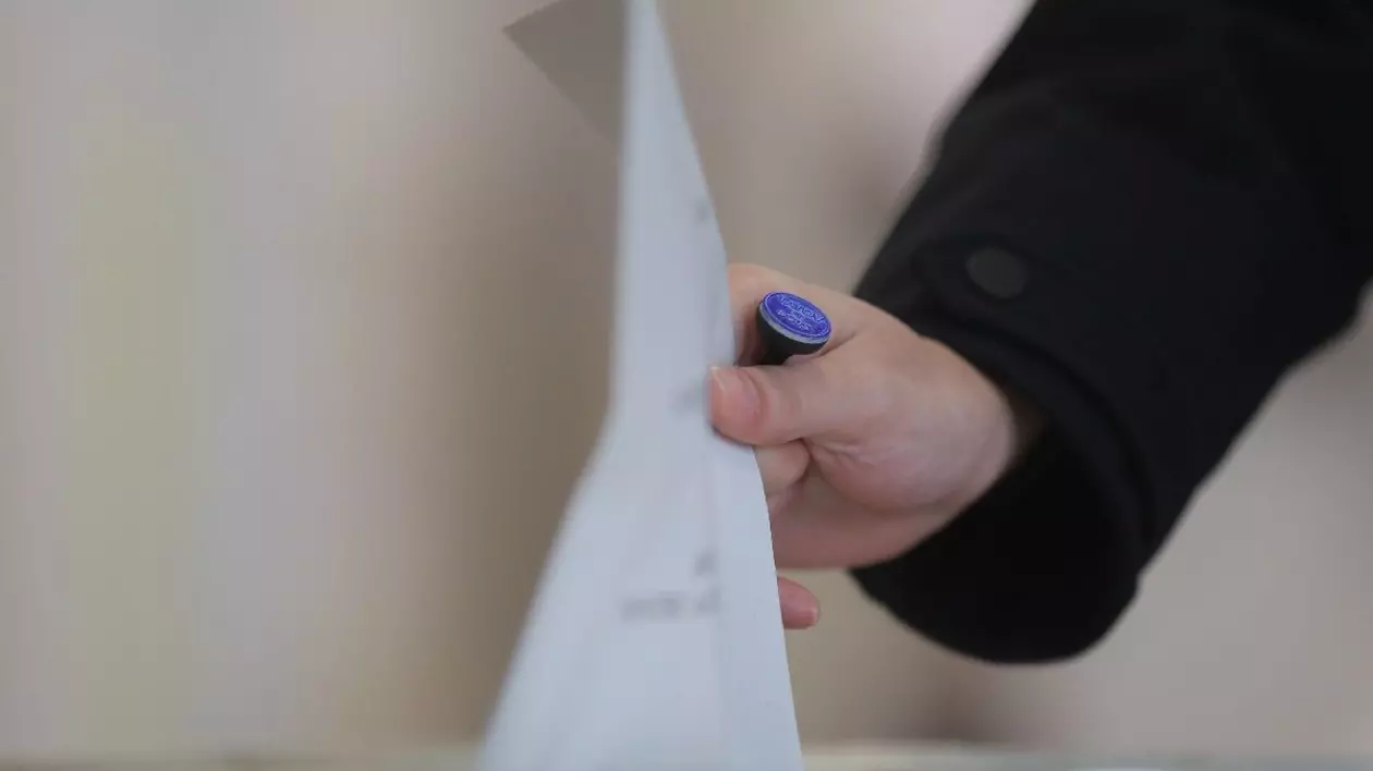 O persoana introduce un buletin de vot intr-o urna, la alegerile parlamentare, in Timisoara, duminica, 1 decembrie 2024.
