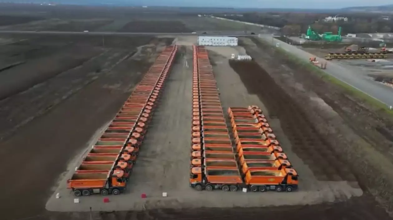Camioane ale companiei UMB, parcate lângă șantierul unei autostrăzi din Adjud, într-o imagine surprinsă de o dronă