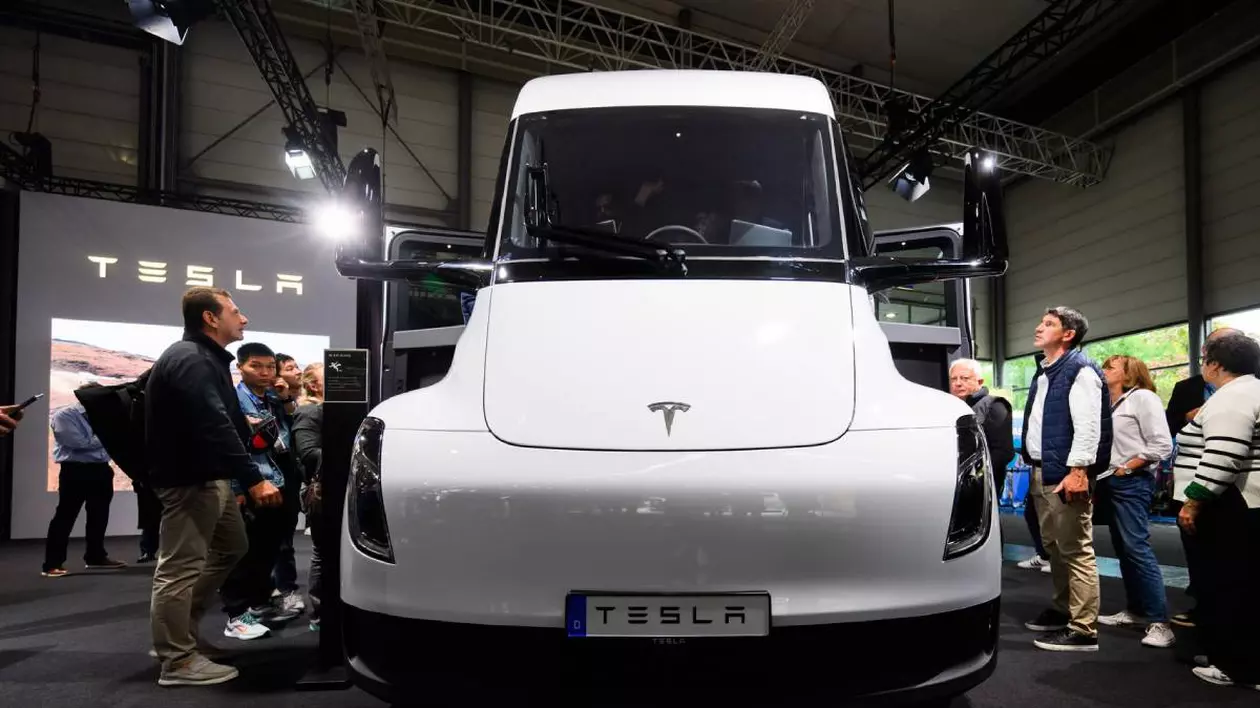 Camionul electric Tesla Semi expus într-un salon auto. În jurul camionului sunt numeroși vizitatori, care îl privesc cu interes.