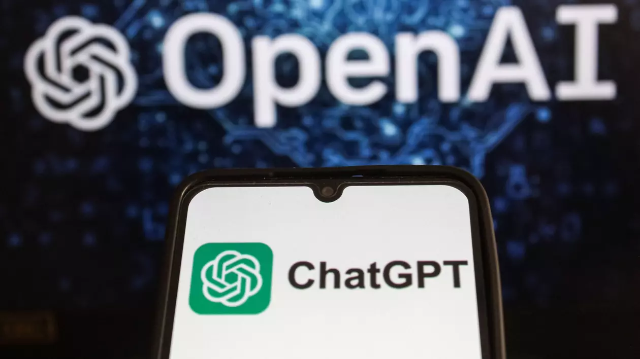 Logo-ul Chat GPT afișat pe ecranul unui telefon, și cel OpenAI, afișat în fața unui fundal albastru cu negru.