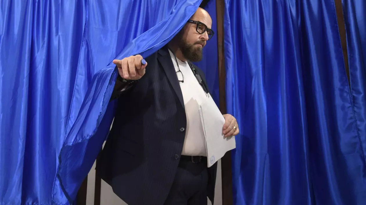 Poză cu Cristian Popescu Piedone ieșind din cabina de vot la alegerile din 9 iunie 2024. Ține în mână buletinul de vot