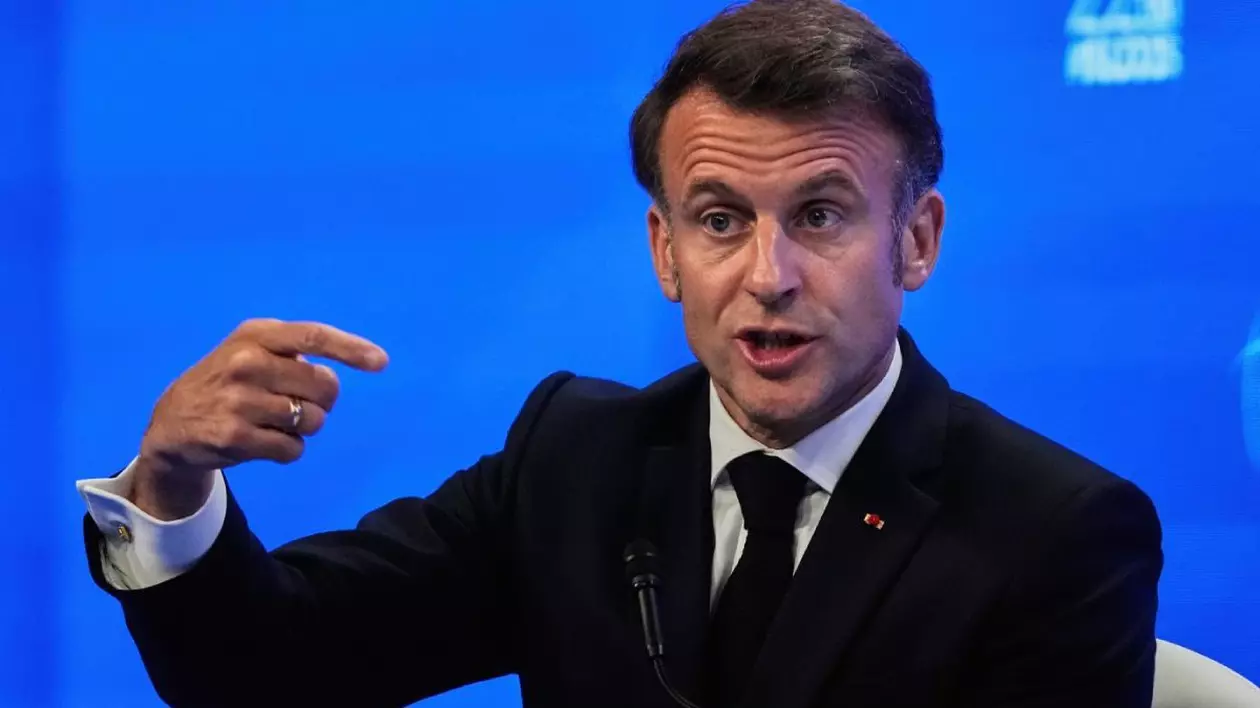 Președintele francez Emmanuel Macron vorbește în fața presei în timpul celui de-al 22-lea summit al Dialogului Shangri-La de la Singapore, vineri, 30 mai 2025. El are mana dreapta ridicata si explica ceva, tinand degetul arătător intins, pe fundal albastru